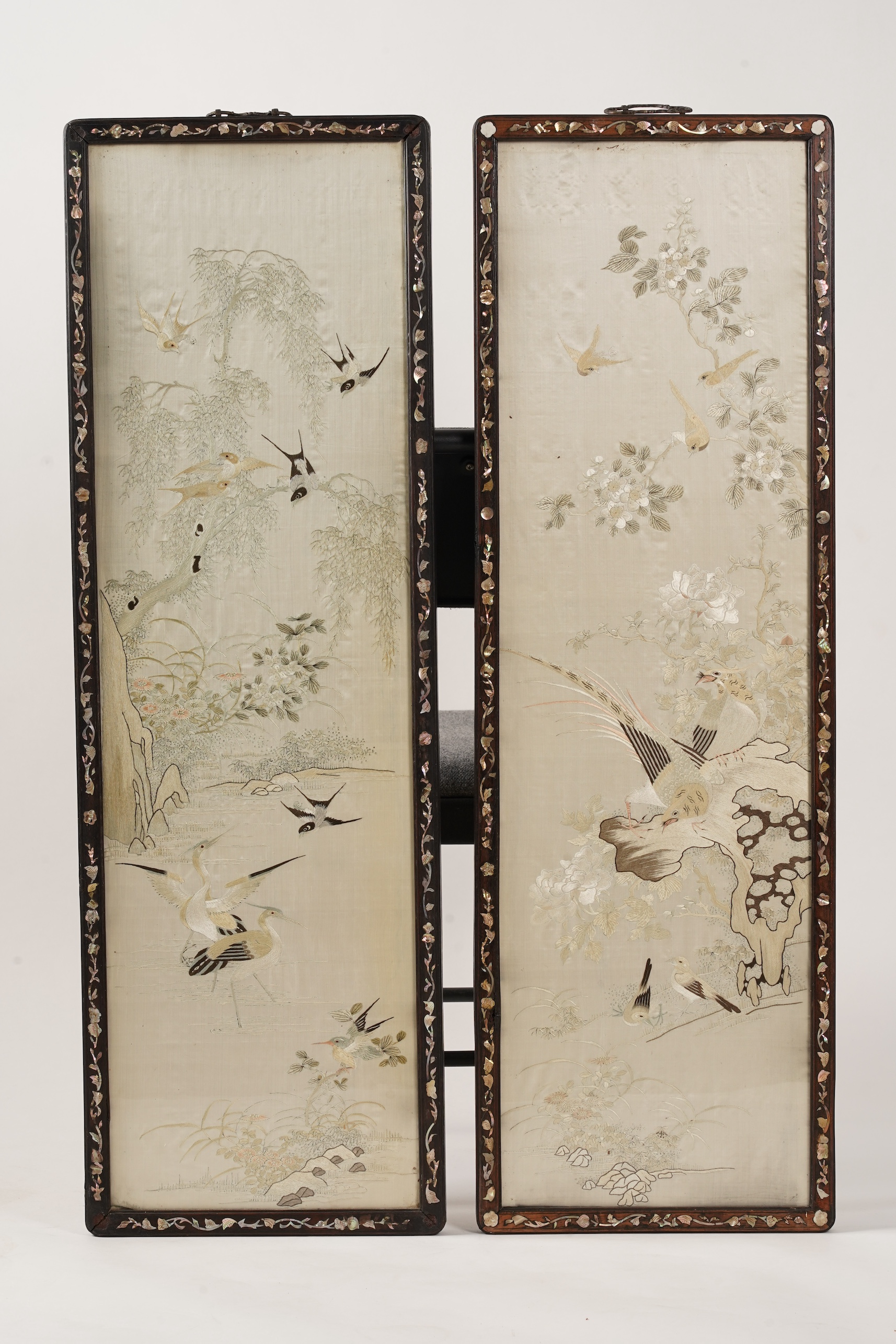 A pair of Chinese embroidered silk ‘bird’ panels, in mother-of-pearl inlaid hongmu frames, late 19th/early 20th century